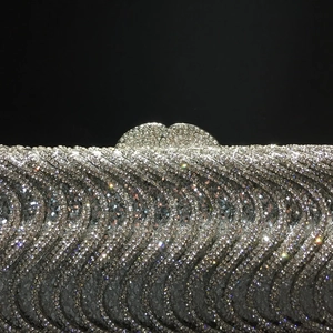 Close-up of silver rhinestone evening bag with wave texture and crystal-encrusted clasp