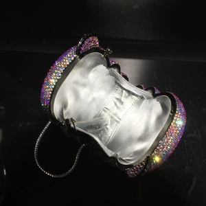 Detail view of colorful bear-shaped rhinestone clutch with silver lining and metal chain