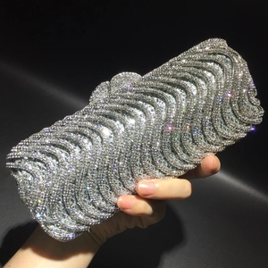 Close-up of silver evening clutch bag with sparkling rhinestone wave pattern textures