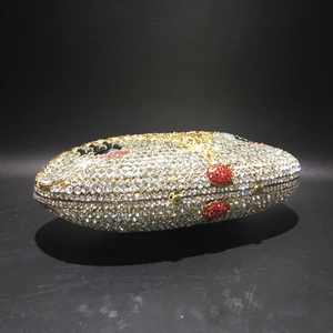 Macro detail of rugby shaped evening clutch with vibrant rhinestone mosaic and metal frame