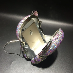 Detailed interior of bear-shaped crystal clutch with a phone for scale comparison