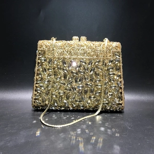 Detailed macro view of sparkling gold evening clutch bag with rhinestones and metal chain