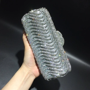 Detailed close-up of a silver evening clutch featuring wave-patterned rhinestones