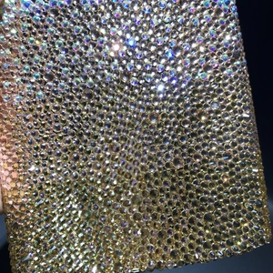Macro shot of gradient champagne crystals on a luxury clutch with shimmering rhinestone texture