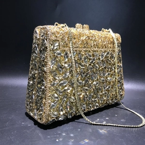 Macro detail of gold evening clutch featuring marquis cut crystals and metal lock clasp