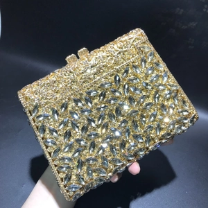 Detail of luxury gold evening clutch bag with marquise rhinestones and floral cutout