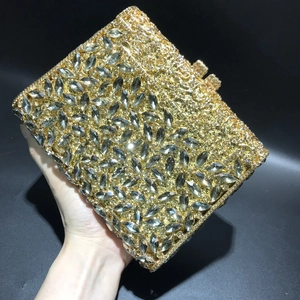 Detail of gold metal clutch bag with marquise rhinestones and hollow floral carving