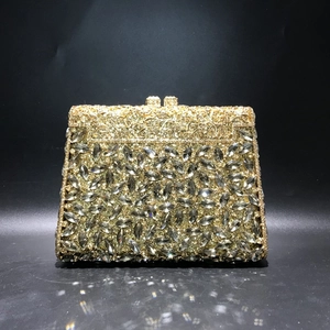 Detailed close-up of golden hollow metal frame and luxury rhinestone evening clutch bag