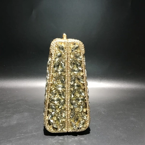 Detail of evening clutch featuring golden metal frame and marquise crystal embellishments
