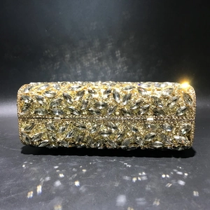 Macro detail of golden evening clutch with marquise-cut rhinestones and metal frame