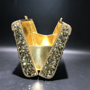 Detailed top view of open golden metal evening clutch bag with marquise rhinestones