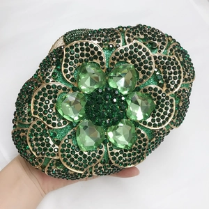 Detail of green floral rhinestones and heart-shaped crystals on luxury metal clutch bag