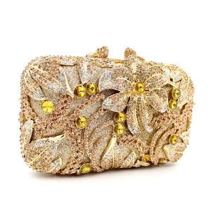 Detail of luxury gold evening clutch with hollow metal structure and amber crystals