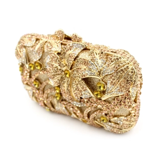 Close-up of golden evening clutch bag featuring intricate floral rhinestone inlay and gems