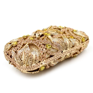 Macro view of gold evening clutch with champagne rhinestones and yellow crystal floral detail