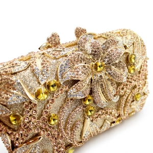 Macro detail of golden metal clutch featuring champagne crystals and floral rhinestone design