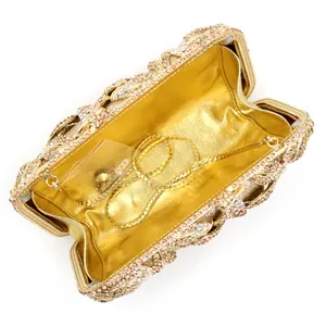 Macro view of pink rhinestone evening clutch featuring gold chain and metal lining detail