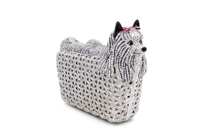 Macro detail of puppy-shaped clutch with hand-set crystals and red bow detail