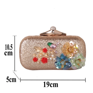 Détail de la pochette de soirée dorée avec broderies florales 3D et un oiseau 19x10,5cm