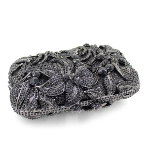 Close-up of black evening clutch with floral patterns of rhinestones and crystals