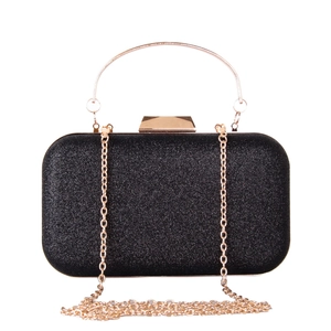 Detail of black glitter evening clutch featuring round gold handle and chain strap