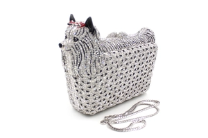 Macro detail of silver Yorkshire Terrier clutch with sparkling crystals and red bow knot