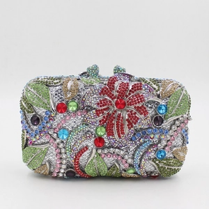 Detail of evening clutch featuring red crystal flowers and green leaves on a metal frame