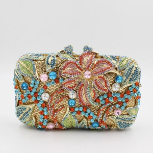 Macro shot of colorful crystals and floral metal patterns on a gold evening clutch bag