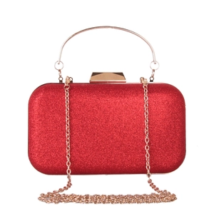 Detail of red sequined clutch bag featuring a gold metal handle and detachable chain