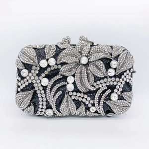 Detail of luxury rhinestone evening clutch bag with floral metalwork and silver crystals
