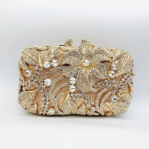 Close-up of gold evening clutch featuring 3D floral metal decor and crystal rhinestones
