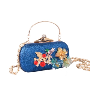Détail du sac de soirée bleu pailleté avec roses en résine, perles et décor d'oiseau peint