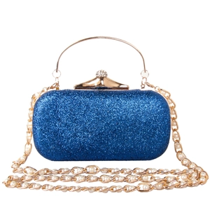 Détail de la pochette bleu marine à paillettes avec bandoulière perle dorée et fermoir