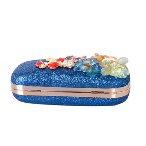 Détail de la pochette de soirée à paillettes bleu foncé avec fleurs 3D et perles