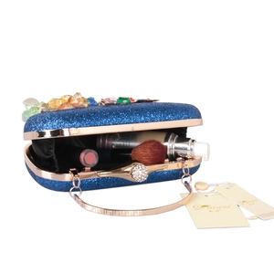 Pochette de soirée bleue pailletée montrant l'intérieur et les fleurs en résine