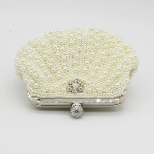 Detailed view of handmade pearl evening clutch with flower crystal buckle and silver frame