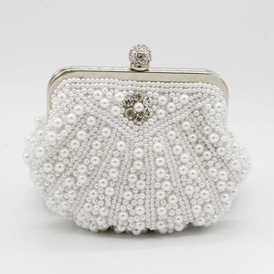 Detailed close-up of handmade pearl evening bag with shell wave pattern and rhinestones
