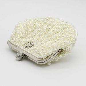 Detailed shot of handmade pearl evening clutch with rhinestone floral and crystal ball clasp