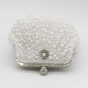 Detailed view of handmade shell-shaped evening clutch with pearls and crystal flower