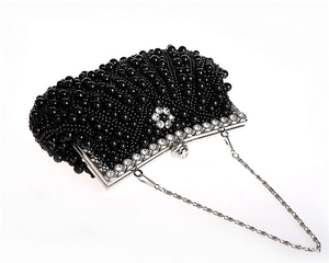 Detail der handgefertigten schwarzen Perlen-Abendtasche mit glitzerndem Strass-Blütenverschluss