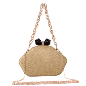 Macro detail of the golden glitter hexagon evening clutch with black crystal bow clasp
