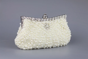 Detailansicht der weißen Perlenstickerei und des Kristallblumenverschlusses der Clutch