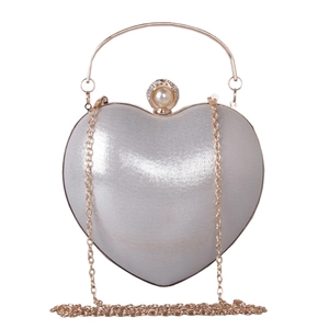Dettaglio borsa cuore argento con chiusura perle strass e manico ad anello oro