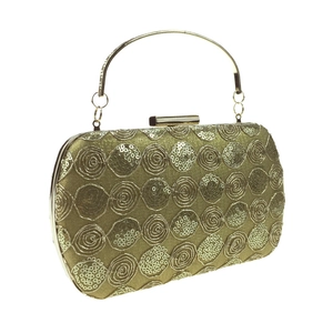 Macro detail of the golden sequins and spiral embroidery on the evening clutch