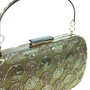 Detail of champagne gold evening clutch with sequins and spiral embroidery patterns