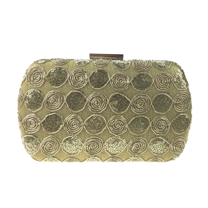 Macro view of gold sequined rose embroidery and metal clasp on this evening clutch