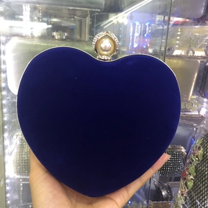 Détail de la pochette de soirée en velours en forme de cœur avec fermoir en perle