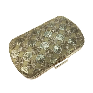 Detailed view of the luxury gold sequin embroidery and polished metal clasp on dinner clutch