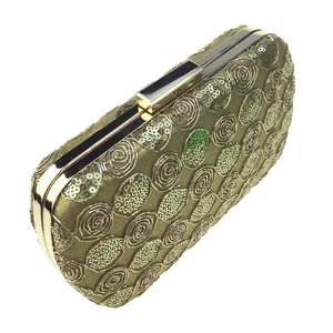 Close-up of champagne gold evening bag with spiral sequins and rectangular metal clasp