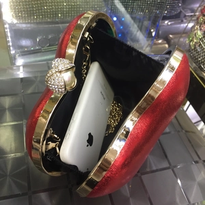 Dettaglio pochette glitter rossa con catena dorata e spazio per lo smartphone
